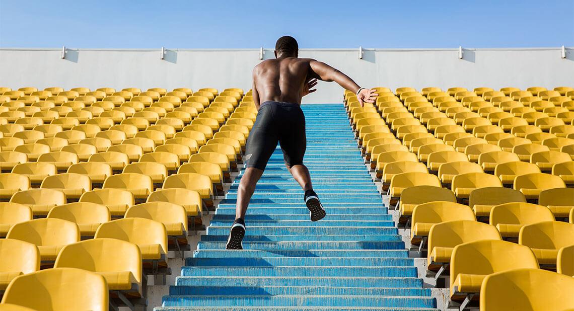 An athlete running up the stairs at a stadium