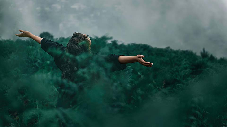 A woman dancing among ferns